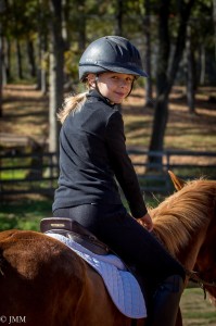 20121027_JMM_00049 Young girl in helmet riding a chestnut pony.
